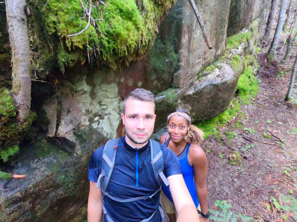 selfie de maeva et anthony du blog de voyage prtir loin devant un rocher de la forêt de la randonnée du mont Menaud