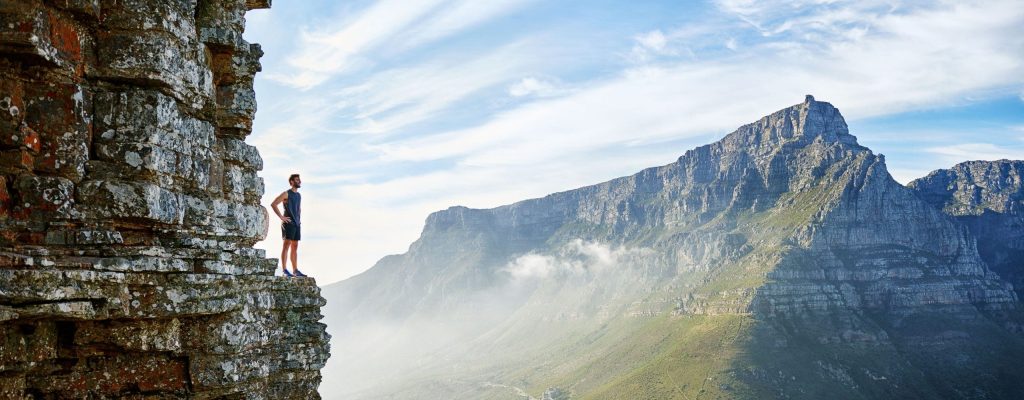 homme sur une montagne face à une vue surprenante